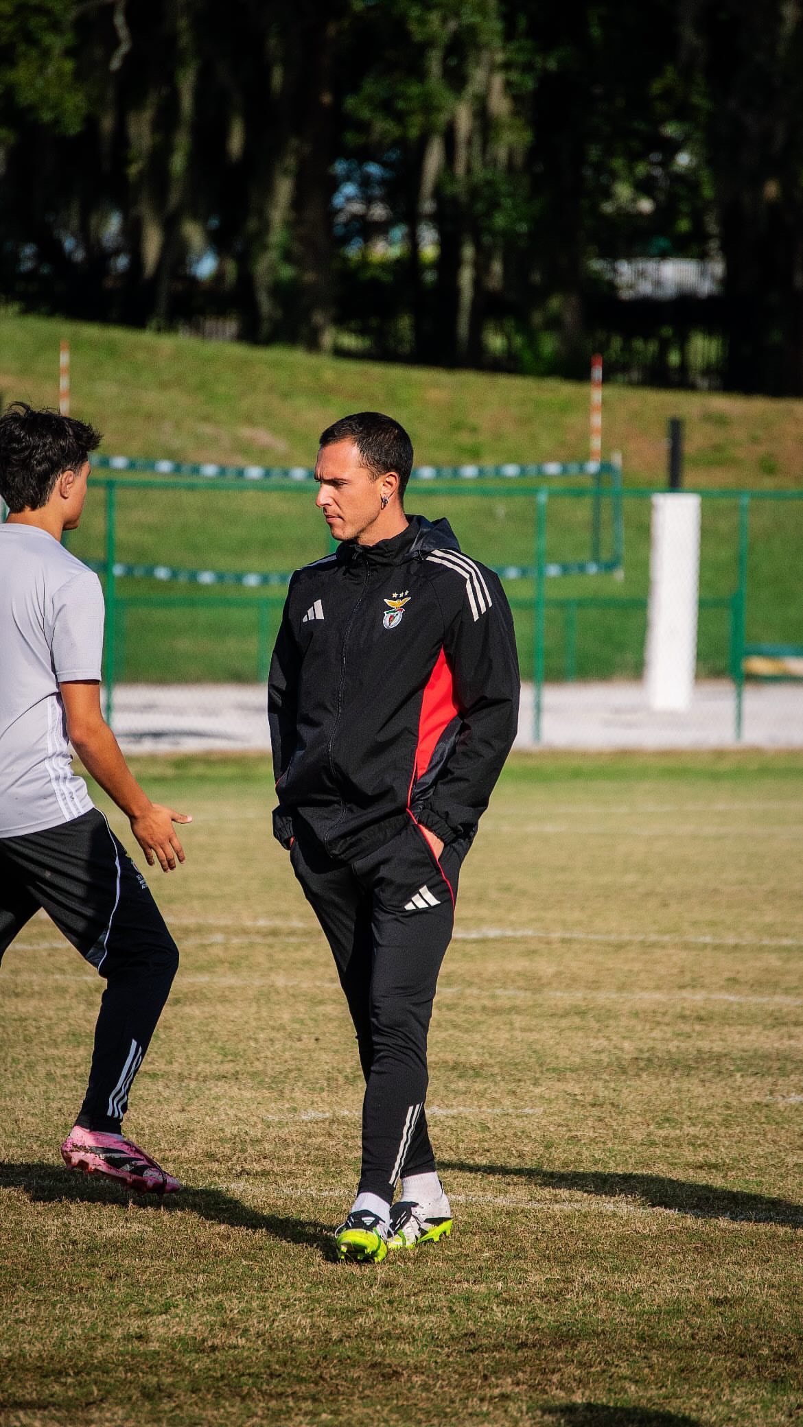 Edoardo on the pitch in Benfica Academy tracksuit, working with players